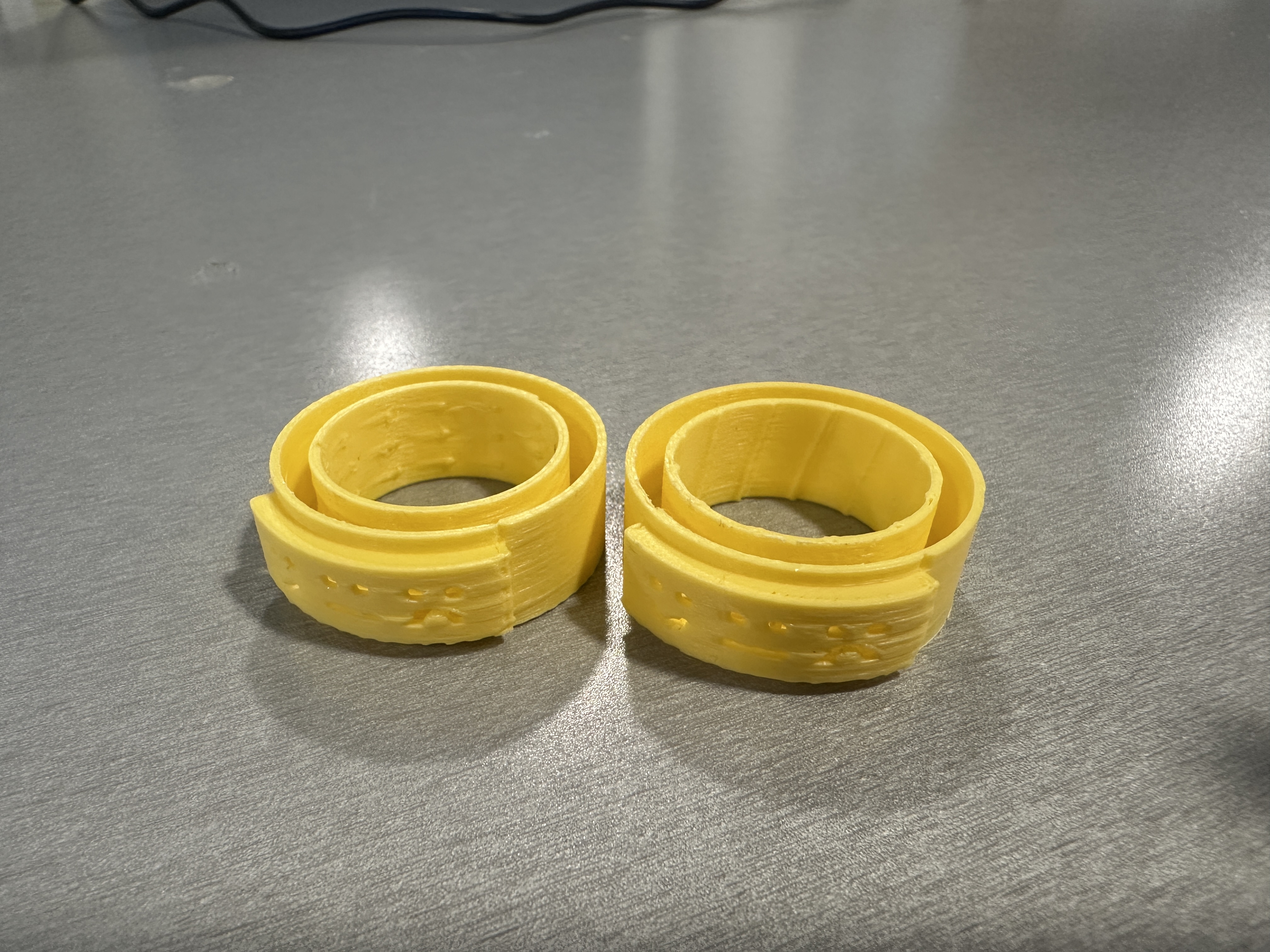 Two yellow 3D-printed Glow Tap prototypes side by side — dot texture and diagonal ridge versions